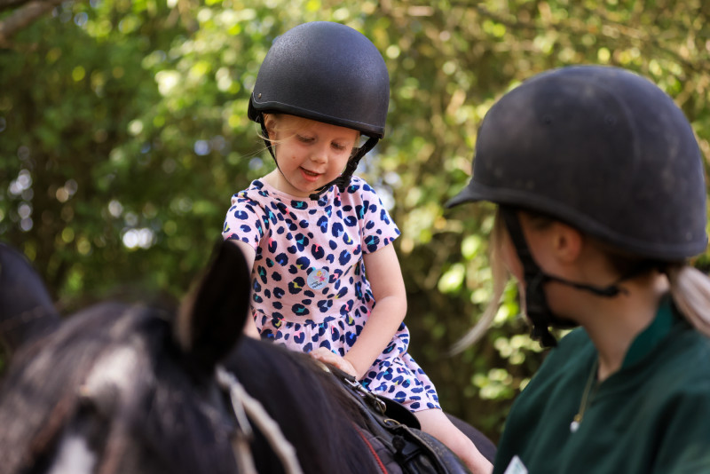 A kid taking a pony ride