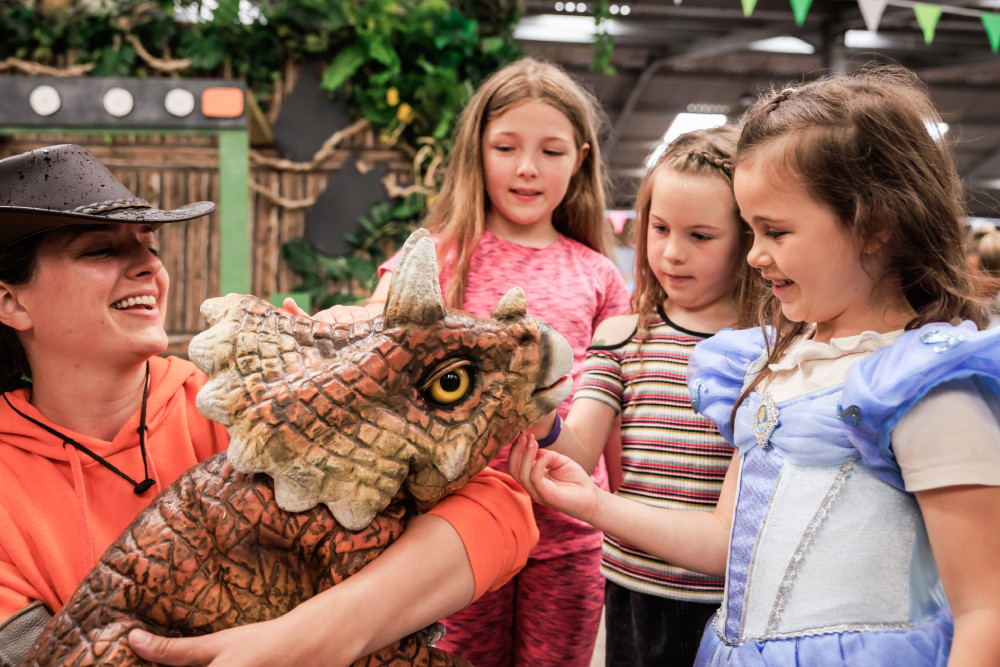 Children petting a dinosaur
